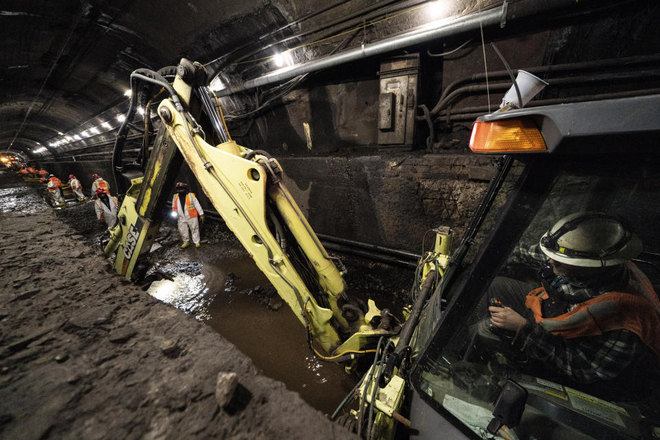 Amtrak workers perform tunnel repairs to a partially flooded train track bed, Saturday, March 20, 2021, in Weehawken, N.J. With a new rail tunnel into New York years away at best, Amtrak is embarking on an aggressive and expensive program to fix a 110-year-old tunnel in the interim. (AP Photo/John Minchillo)