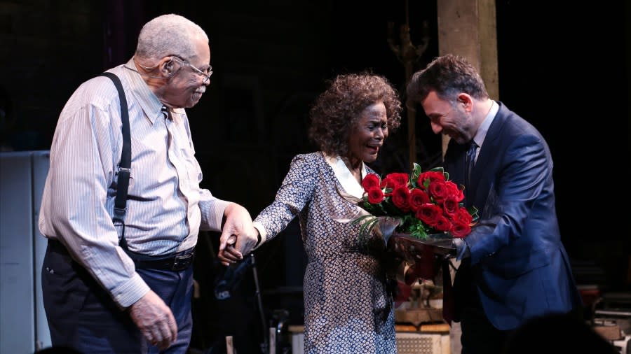 Cicely Tyson smiles as Leonard Foglia hands her a bouquet of red roses. James Earl Jones smiles as he looks on and holds Tyson's other hand.