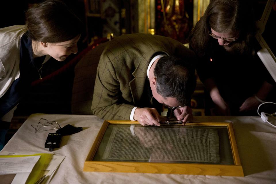 The Salisbury Cathedral copy of the Magna Carta is looked at by (L-R) Oriana Calman, parliamentary archive conservator, Chris Woods, the director of the National Conservation Service and Salisbury Cathedral archivist Emily Naish, before being displayed in a cabinet alongside the other three surviving original parchment engrossments of the Magna Carta, as they are displayed to mark the 800th anniversary of the sealing of the Magna Carta in 1215, in the Queen's Robing Room at the Houses of Parliament in London February 5, 2015. The original copies were displayed on Thursday for one day at the opening of the exhibition "Magna Carta and Parliament". REUTERS/Matt Dunham/pool (BRITAIN - Tags: POLITICS SOCIETY)