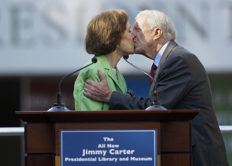 FILE - This Oct. 1, 2009 file photo shows former President Jimmy Carter getting a kiss from his wife Rosalynn as she introduces him during a reopening ceremony for the newly redesigned Carter Presidential Library in Atlanta. Jimmy Carter and his wife Rosalynn celebrate their 75th anniversary this week on Thursday, July 7, 2021. (AP Photo/John Bazemore, File)
