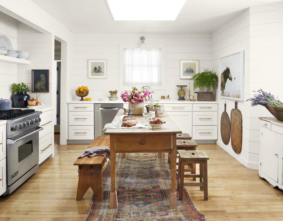a white kitchen with a farmhouse in the middle