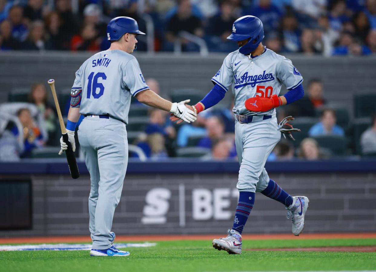 Mookie Betts, right, celebrates with Dodgers teammate Will Smith after scoring on a sacrifice fly from Freddie Freeman.