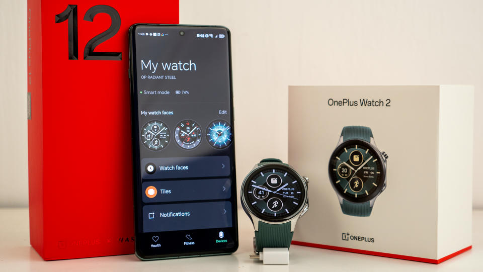 El OnePlus Watch 2 con un teléfono OnePlus 12 y sus respectivas cajas