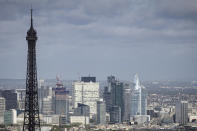 FILE - The business district La Defense in background, and part of the Eiffel Tower are seen on April 15, 2024 in Paris. From taxing billionaires and making gasoline cheaper to earlier retirement and higher wages, opposing left-right blocs in France's election are making costly campaign promises that are spooking investors as they seek to woo voters and sideline President Emmanuel Macron. (AP Photo/Aurelien Morissard, File)