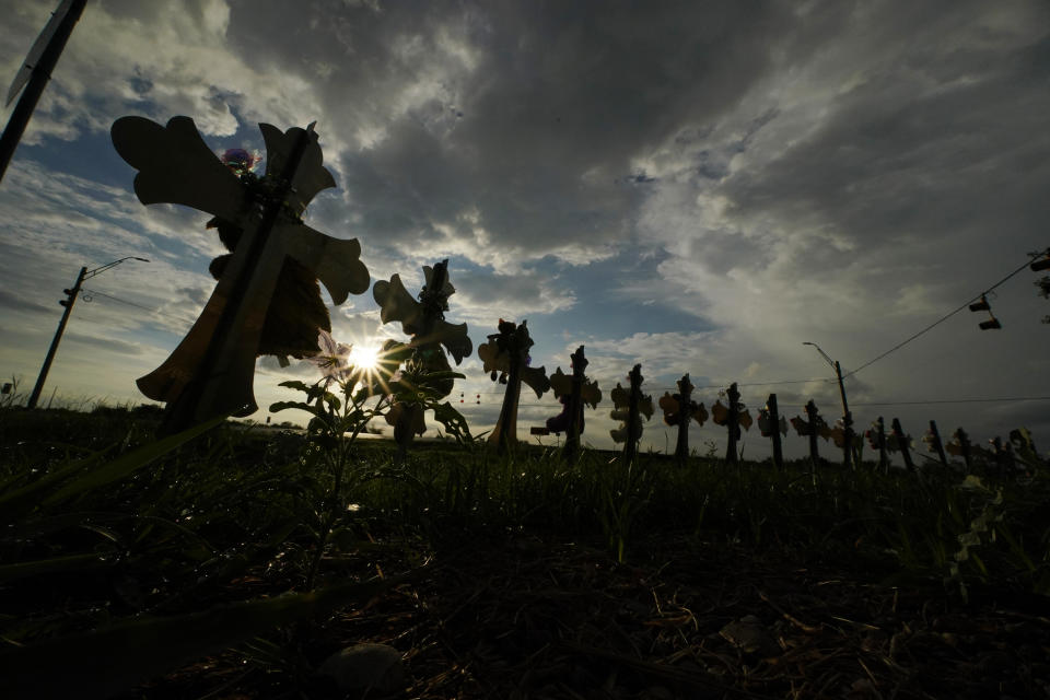 FILE - Vehicles pass crosses placed to honor the victims of the shootings at Robb Elementary School, Thursday, Aug. 25, 2022, in Uvalde, Texas. An Associated Press analysis found many U.S. states barely use the red flag laws touted as the most powerful tool to stop gun violence before it happens, a trend blamed on a lack of awareness of the laws and resistance by some authorities to enforce them even as shootings and gun deaths soar. (AP Photo/Eric Gay, File)