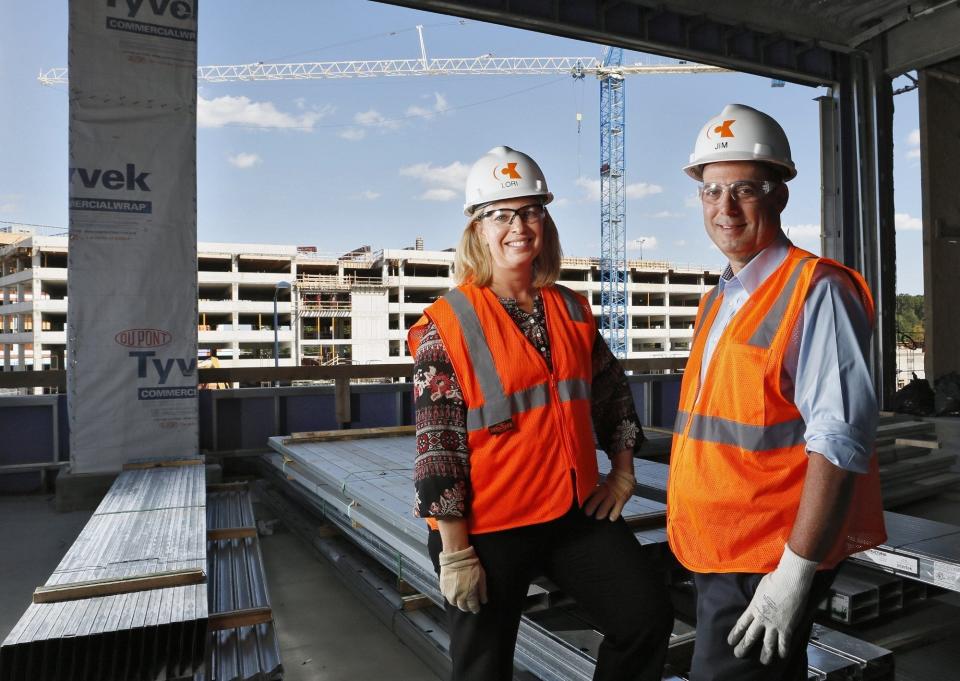 CEO Lori Gillett and President Jim Negron of Corna Kokosing, pictured in 2019. In the background is the Midtown Easton Garage their company has built at Eastern Town Center.