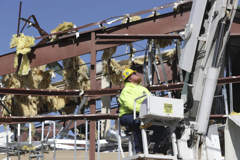 Electrical worker Tyler Smith works on power lines in front of one of the damaged buildings of Mount Bethel Missionary Baptist Church, Sunday, March 8, 2020, in Nashville, Tenn. The church's congregation held their service in a tent in the parking lot near the church facilities, which were heavily damaged by a tornado March 3. (AP Photo/Mark Humphrey)