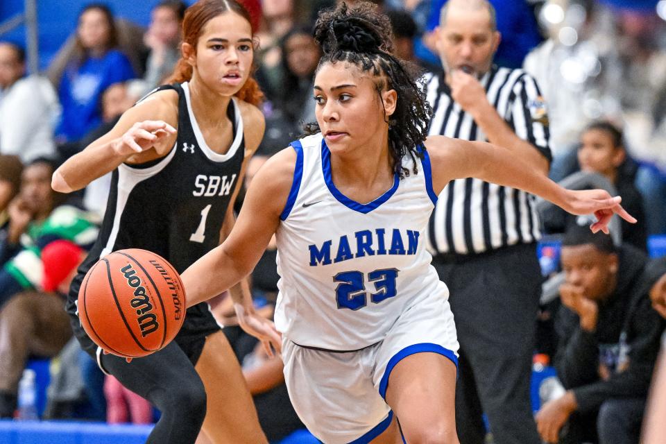 Marian Knights guard Shayla Alexander (23) dribbles as Washington Panthers guard Amiyah Reynolds (1) defends in the second half Friday, Nov. 11, 2022, at Marian High School.