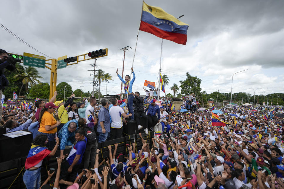 La líder de la oposición María Corina Machado sostiene una bandera venezolana mientras saluda a sus partidarios durante un mitin de campaña del candidato presidencial Edmundo González, en Maturín, Venezuela, el sábado 20 de julio de 2024. Las elecciones presidenciales están programadas para el 28 de julio. (Foto AP/Matías Delacroix)