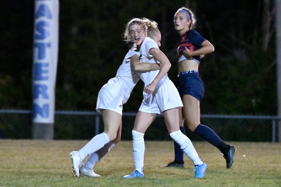 Assumption's Anna Grace Gibson (7) is hugged by a teammate after scoring a goal = during the first half of their 7th Region Championship game against Sacred Heart, Wednesday, Oct. 11, 2023, in Louisville, Ky.