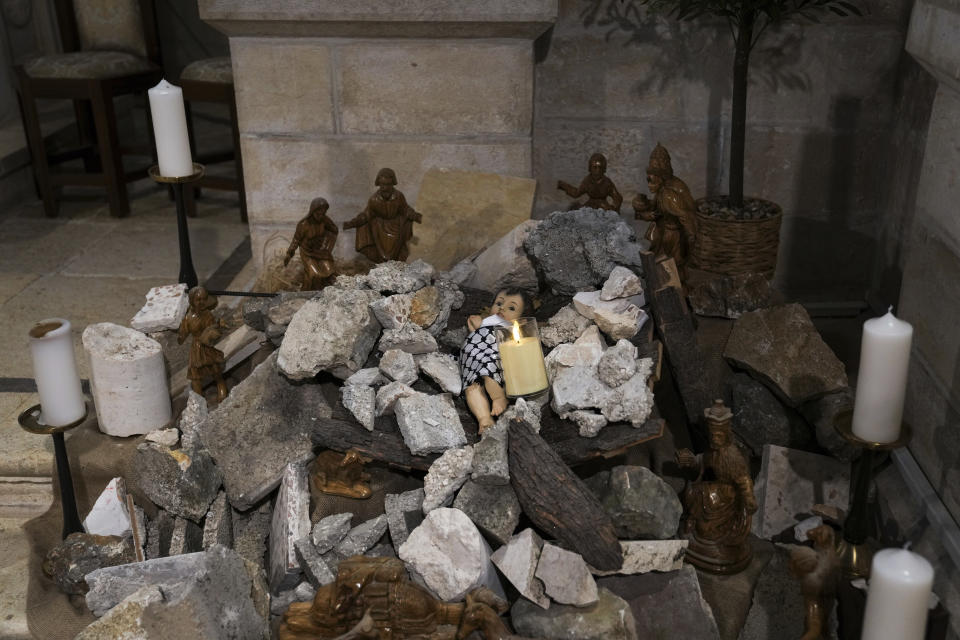 An installation of a scene of the Nativity of Christ with a figure symbolizing baby Jesus lying amid the rubble, in reference to Gaza, inside an Evangelical Lutheran Church in the West Bank town of Bethlehem, Sunday, Dec. 10, 2023. World-famous Christmas celebrations in Bethlehem have been put on hold due to the ongoing Israel-Hamas war. (AP Photo/Mahmoud Illean)