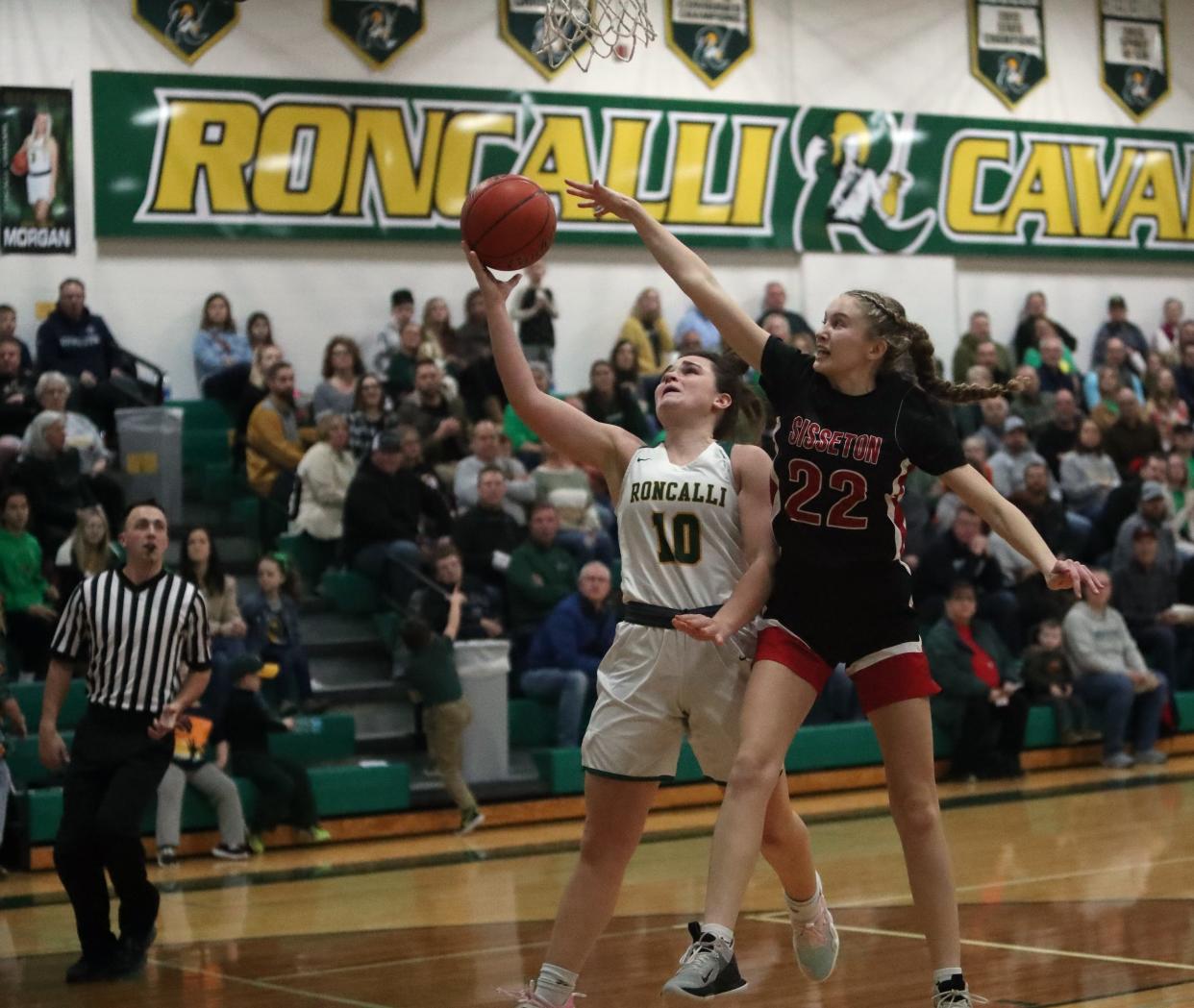 Aberdeen Roncalli's Olivia Hanson goes up for a layup while Sisseton's Emmalee Nielsen (22) goes for a block inside the Roncalli High School.