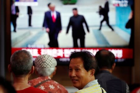 South Korean people watch a live broadcast on a meeting between North Korean leader Kim Jong Un and U.S. President Donald Trump at the truce village of Panmunjom inside the demilitarised zone separating the two Koreas, in Seoul