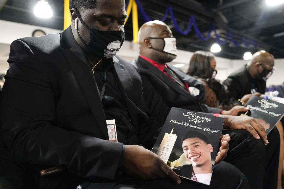 FILE - Brandon Williams, nephew of George Floyd, displays the program for the funeral services of Daunte Wright at Shiloh Temple International Ministries in Minneapolis, Thursday, April 22, 2021. Wright was fatally shot by a police officer during a traffic stop. The funerals of Black Americans who are the victims of police brutality or white supremacist violence serve both as outlets for private mourning and as venues to air shared grief and demand justice. (AP Photo/John Minchillo, Pool, File)