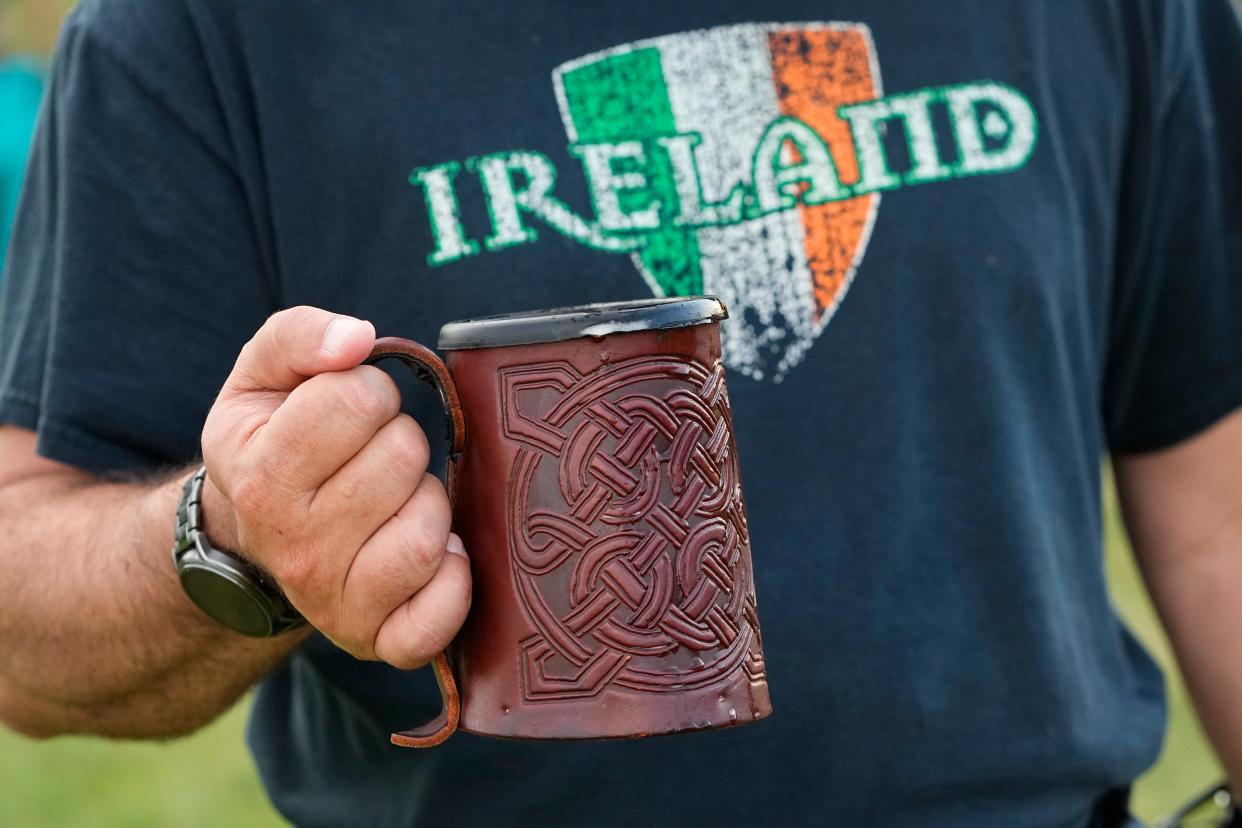 Mike Murphy of the Northwest Side carries a mug of Guinness beer during the 2022 Dublin Irish Festival.