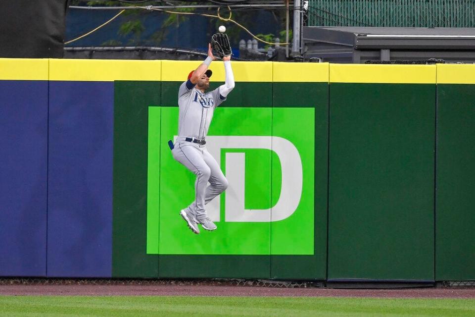 Tampa Bay Rays center fielder Kevin Kiermaier, a three-time Gold Glove recipient, catches a fly ball in front of the wall.