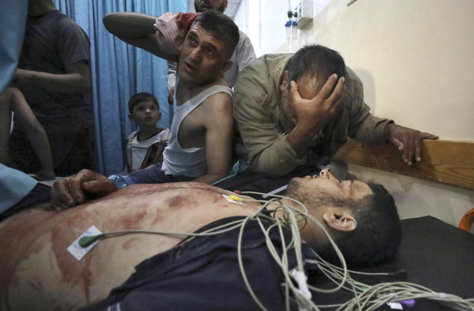 Mourners react in a hospital over the body of a man who died following an explosion in the town of Beit Lahiya, northern Gaza Strip, on Monday, May 10, 2021. The Hamas militant group launched a rare rocket strike on Jerusalem after hundreds of Palestinians were hurt in clashes with Israeli police at an iconic mosque. Israel responded Monday with airstrikes across the Gaza Strip, where 20 people, including nine children, were killed in fighting. (AP Photo/Mohammed Ali)