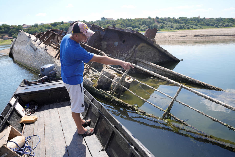 Ivica Skodric, a 37-year old local fisherman, points at the wreckage of a World War Two German warship in the Danube in Prahovo, Serbia August 18, 2022. REUTERS/Fedja Grulovic