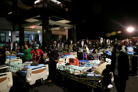 Patients are seen outside a hospital following a strong earthquake on nearby Lombok island, at a government hospital near Denpasar, Bali, Indonesia. REUTERS/Johannes P. Christo