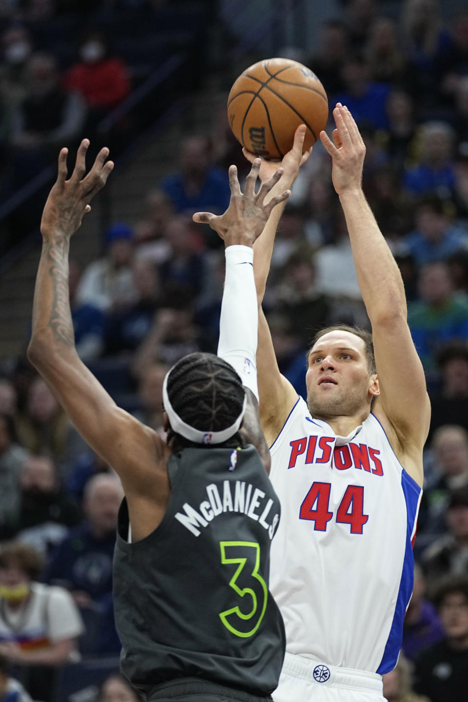 Detroit Pistons forward Bojan Bogdanovic (44) shoots while defended by Minnesota Timberwolves forward Jaden McDaniels (3) during the first half of an NBA basketball game, Saturday, Dec. 31, 2022, in Minneapolis. (AP Photo/Abbie Parr)