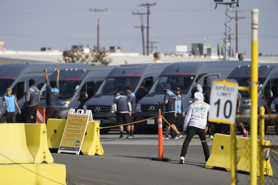 Amazon drivers cheer as they go back to their their delivery vans, as their logistics systems is announced to be back online at the Amazon Delivery Station in Rosemead, Calif., Tuesday, Dec. 7, 2021. Amazon Web Services suffered a major outage. The company provides cloud computing services to individuals, universities, governments and companies, including The Associated Press. (AP Photo/Damian Dovarganes)