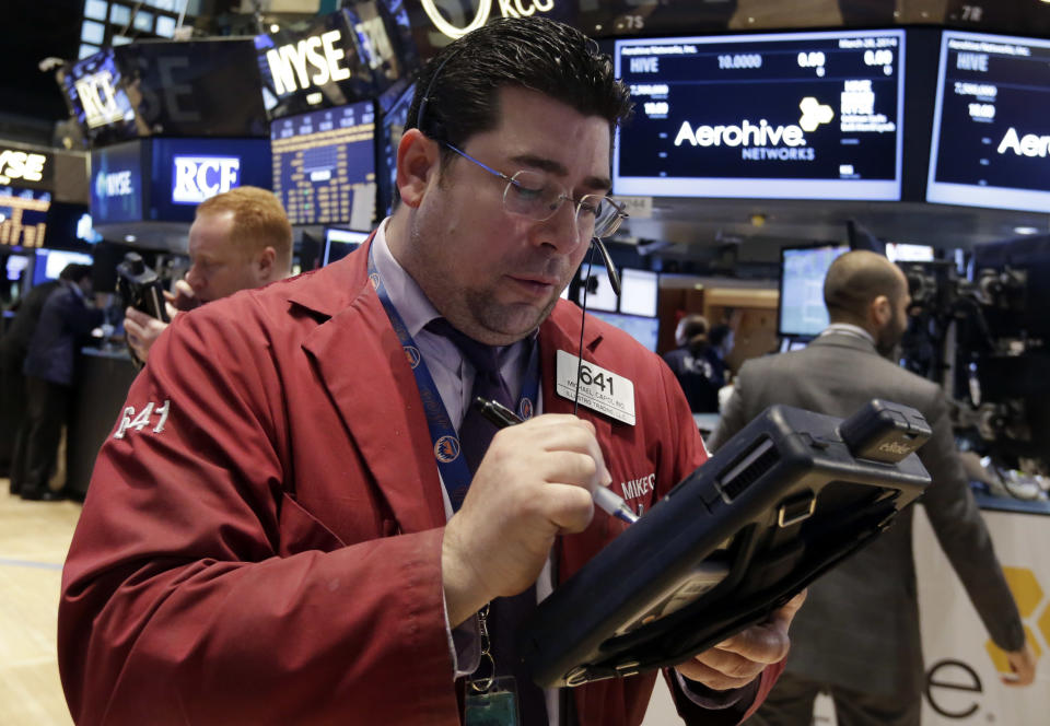 Trader Michael Capolino, center, works on the floor of the New York Stock Exchange Friday, March 28, 2014. After two days of declines, stocks were moving higher in early trading Friday following news that U.S. consumer spending rose the most in three months in February. (AP Photo/Richard Drew)