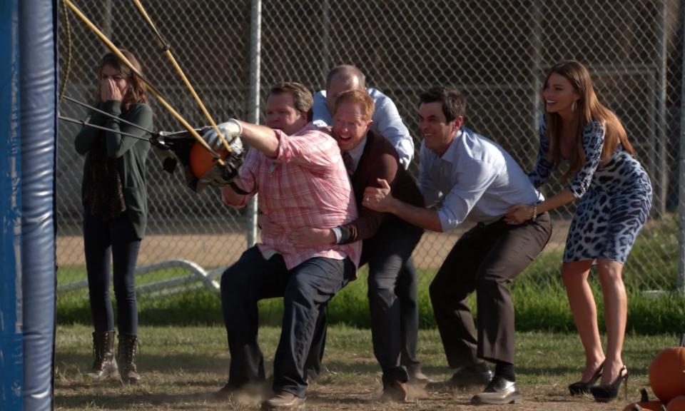 the whole family gathers around the giant slingshot to throw the pumpkin