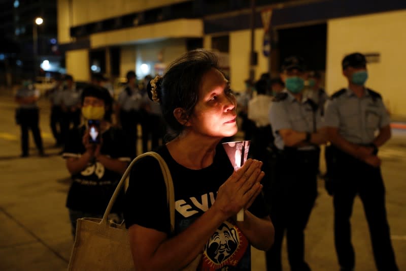 Police officers stand guard at a candlelight vigil ahead of the 31st anniversary of the crackdown of pro-democracy protests at Beijing's Tiananmen Square, in Hong Kong