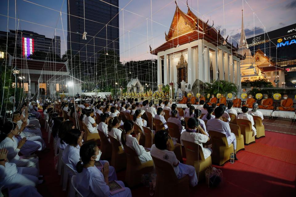 Thai people and Buddhist monks chant during a prayer rite at Wat Pathum Wanaram temple in Bangkok, (EPA)