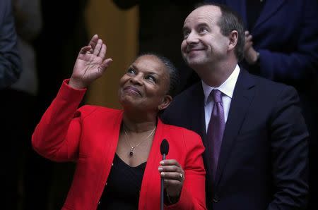 Outgoing French Justice Minister Christiane Taubira (L) reacts with newly-appointed French Justice Minister Jean-Jacques Urvoas (R) during a handover ceremony at the Justice Ministry in Paris, France, January 27, 2016. REUTERS/Christian Hartmann