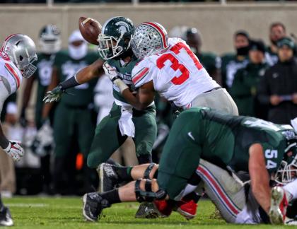 Spartans RB Jeremy Langford (33) has the ball knocked away CB Damon Webb. (USA TODAY Sports)