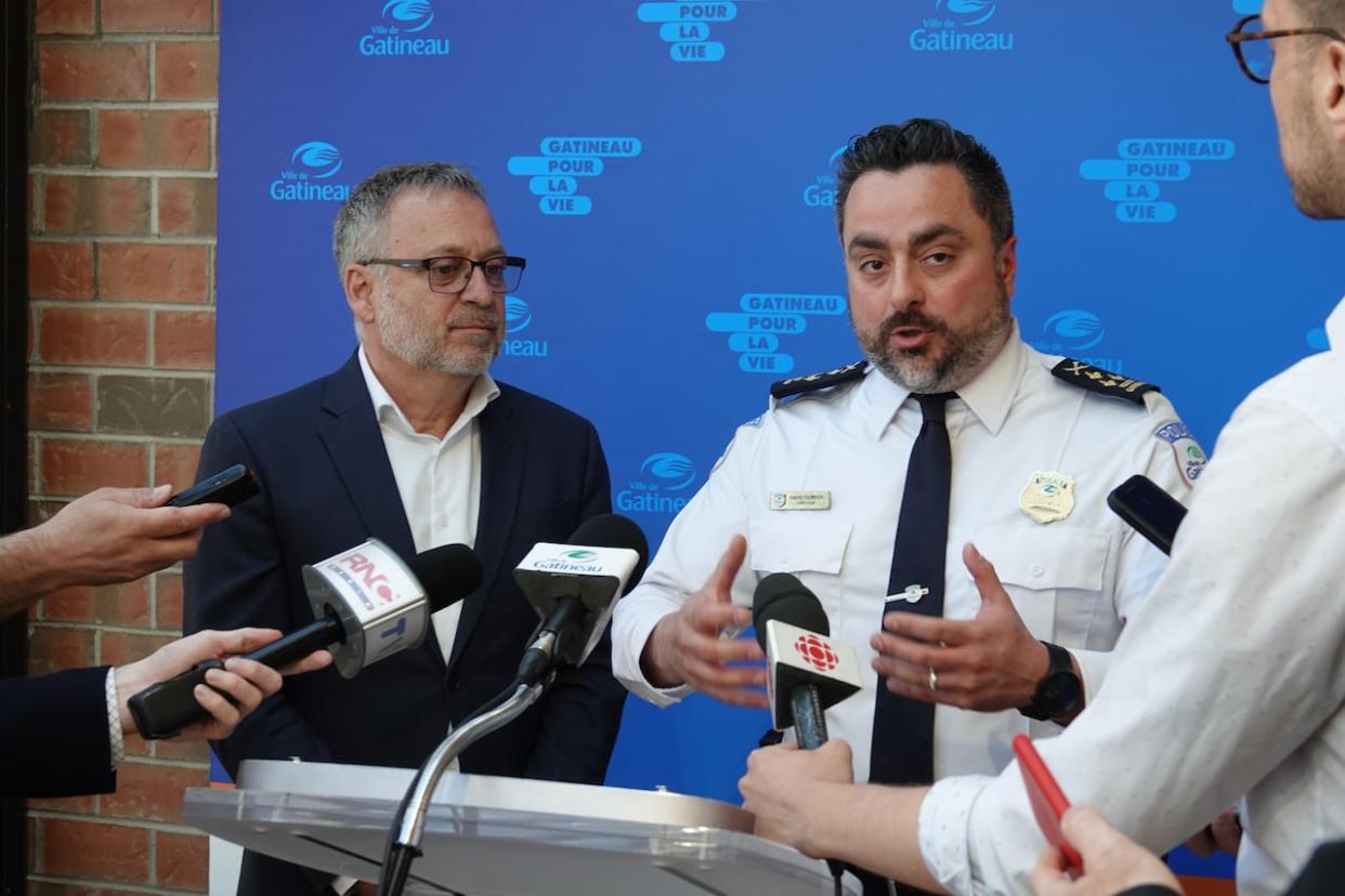 Gatineau's chief of police Simon Fournier, right, and mayor Daniel Champagne speak to reporters Tuesday following council's vote to approve a new $187 million police headquarters. (Giacomo Panico/CBC - image credit)