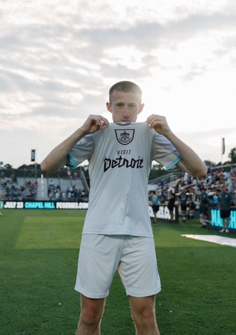 Burnley defender Liam Waddington shows off the Visit Detroit sponsor on the front of the white Burnley jersey.