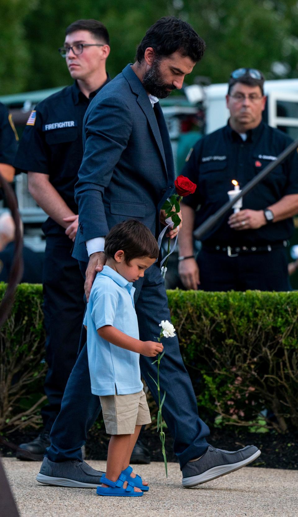 Jim Sheils, Katie Seley's fiance, with his son before placing flowers at the vigil honoring both victims and survivors of the recent flash flooding in Upper Makefield at the 911 Memorial Garden of Reflection in Yardley on Sunday, July 23, 2023.