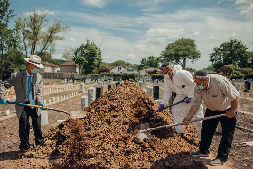 Rabbi Shmuel Plafker, an Orthodox chaplain, left, and volunteers place the last shovelfuls of dirt upon Ellen Torron’s grave.<span class="copyright">Sasha Arutyunova for TIME</span>