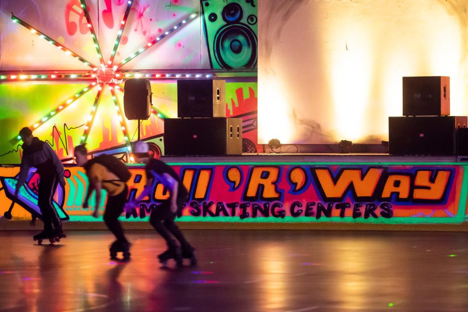 A trio of skaters fly around a corner during "Glow Skate" night at Roll 'R' Way Family Skating Center on Friday, December 3, 2021, in York.