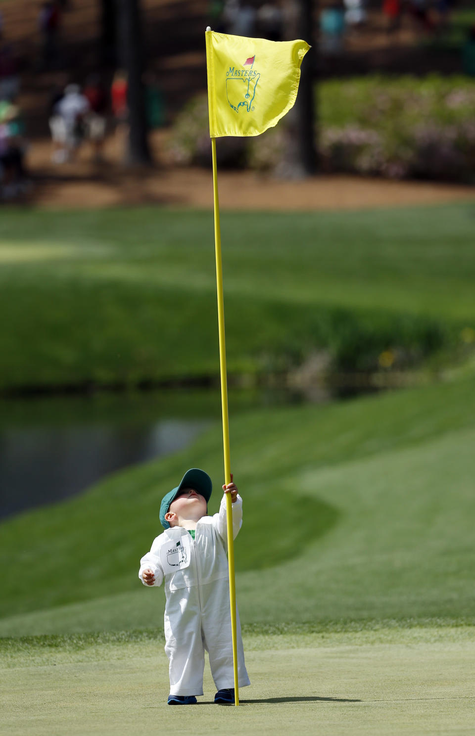 Scott Stallings's son Finn looks at the flag on the fourth green during the par three competition at the Masters golf tournament Wednesday, April 9, 2014, in Augusta, Ga. (AP Photo/Matt Slocum)