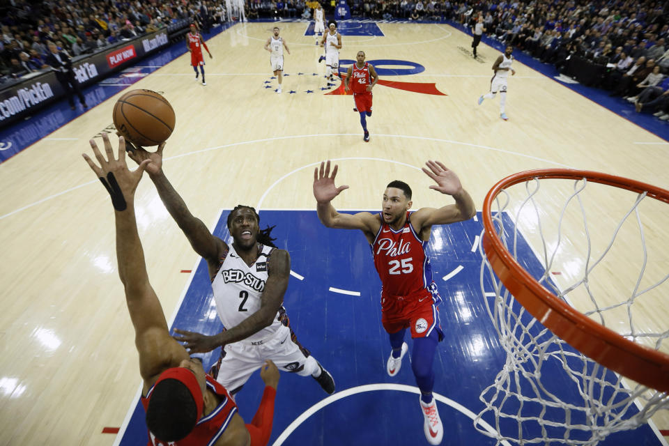 Brooklyn Nets' Taurean Prince, center, goes up for a shot between Philadelphia 76ers' Tobias Harris, left, and Ben Simmons during the first half of an NBA basketball game, Wednesday, Jan. 15, 2020, in Philadelphia. (AP Photo/Matt Slocum)