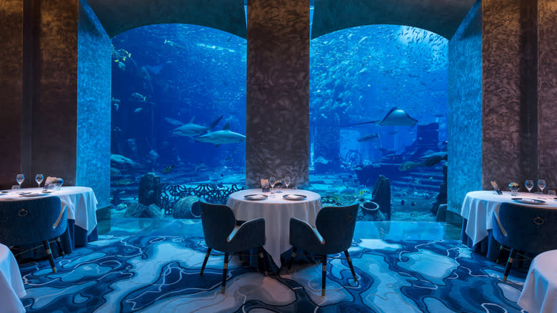 Tables next to aquarium with sharks at Ossiano in Dubai