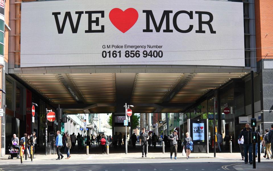 A sign that reads "We Love MCR" is displayed in solidarity above a street in central Manchester - Credit: BEN STANSALL/AFP/Getty Images