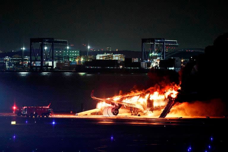 Esta foto proporcionada por Jiji Press muestra un avión de Japan Airlines en llamas en una pista del Aeropuerto de Haneda en Tokio el 2 de enero de 2024. 