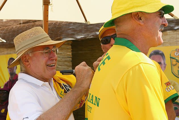 Then-Prime Minister John Howard signs the back of the shirt worn by former Australian fast bowler Dennis Lillie in 2007. Photo: Getty