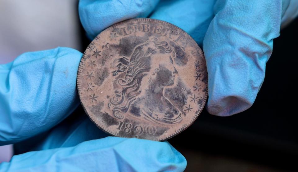 fingers holding old coin