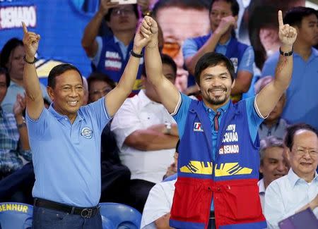 Philippine Vice President Jejomar Binay (L), one of the contenders in the May 2016 presidential election, and Filipino boxer Manny Pacquiao, who is running for senator, make their political party sign during the start of campaigning for the national elections in Mandaluyong city, Metro Manila February 9, 2016. REUTERS/Erik De Castro