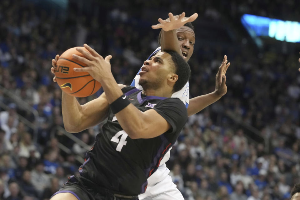 TCU guard Jameer Nelson Jr. (4) goes up with the ball past BYU forward Fousseyni Traore (45) during the first half of an NCAA college basketball game Saturday, March 2, 2024, in Provo, Utah. (AP Photo/George Frey)
