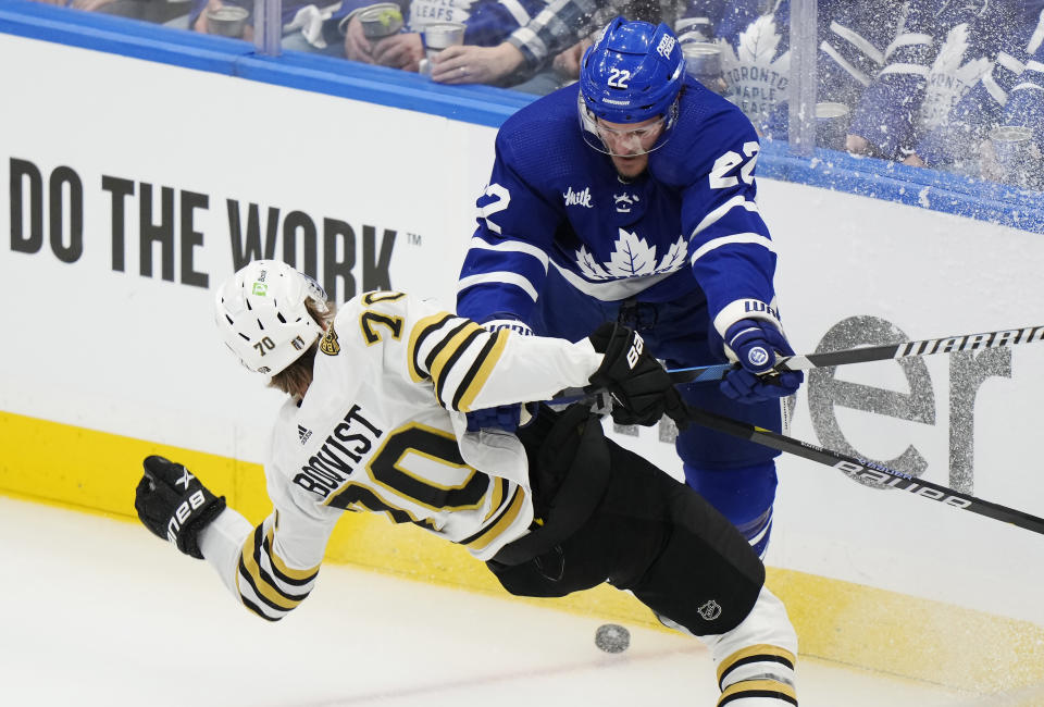 Toronto Maple Leafs' Jake McCabe (22) checks Boston Bruins' Jesper Boqvist (70) during the first period in Game 6 of an NHL hockey Stanley Cup first-round playoff series in Toronto on Thursday, May 2, 2024. (Frank Gunn/The Canadian Press via AP)