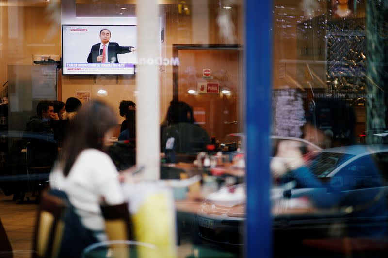 Customers at a Japanese restaurant watch on TV the live news conference of former Nissan chairman Carlos Ghosn in Paris