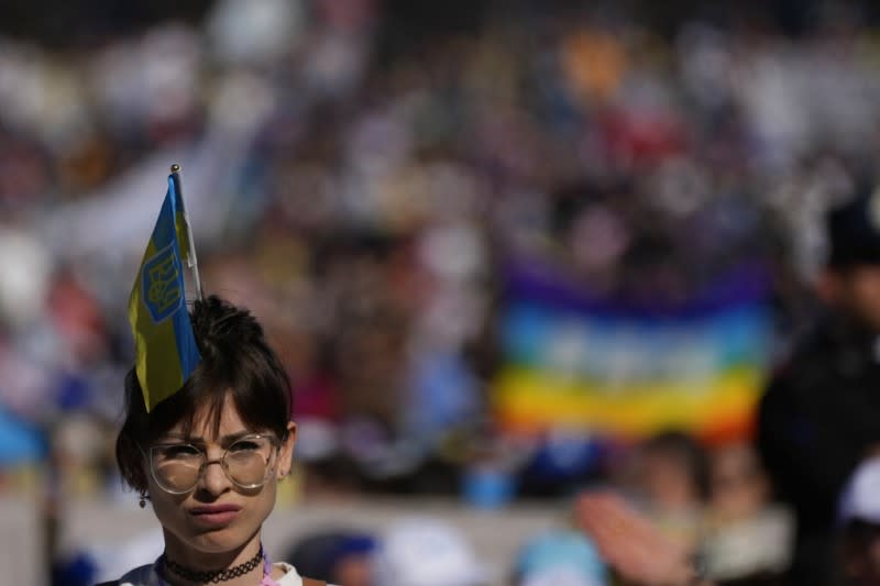 <cite>2022年4月18日，一位在梵蒂岡聖彼得廣場聆聽教宗方濟各的信徒在頭上裝飾著烏克蘭國旗。（美聯社）</cite>