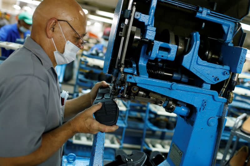 Un trabajador cose zapatos en una máquina en un fabricante de calzado Full Time, en Caracas