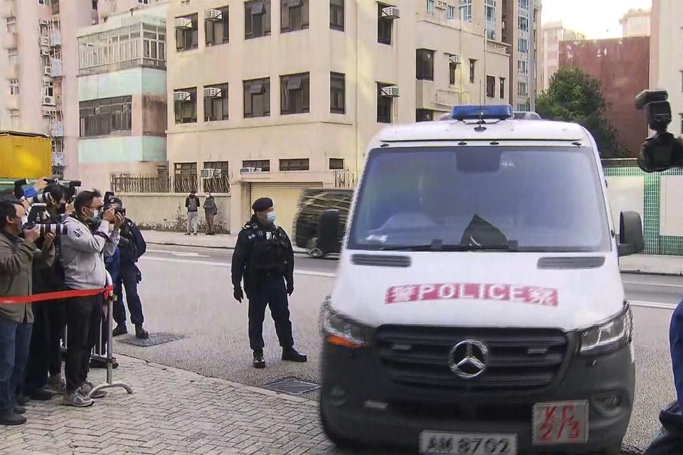 In this image taken from video footage run by TVB Hong Kong, journalists film a police van believed to be carrying relatives of murdered model Abby Choi on its arrival at the Kowloon City Law Courts Building in Hong Kong, Monday, Feb. 27, 2023. The ex-husband and former in-laws of a slain Hong Kong model and influencer appeared in court Monday on a joint murder charge after police found her body parts in a refrigerator. (TVB Hong Kong via AP)